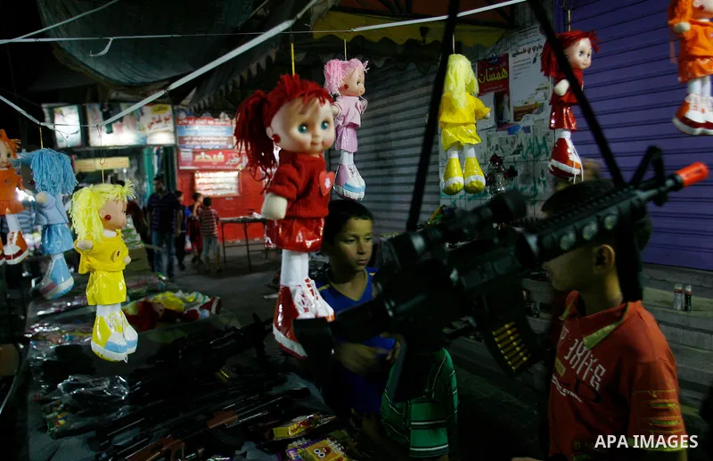 Palestinian children buy toys at a market in the southern Gaza strip town of Rafah on Aug 16,2012, as Muslims over the world prepare to celebrate Eid al-Fitr, a three day holiday marking the end of the religious month of...