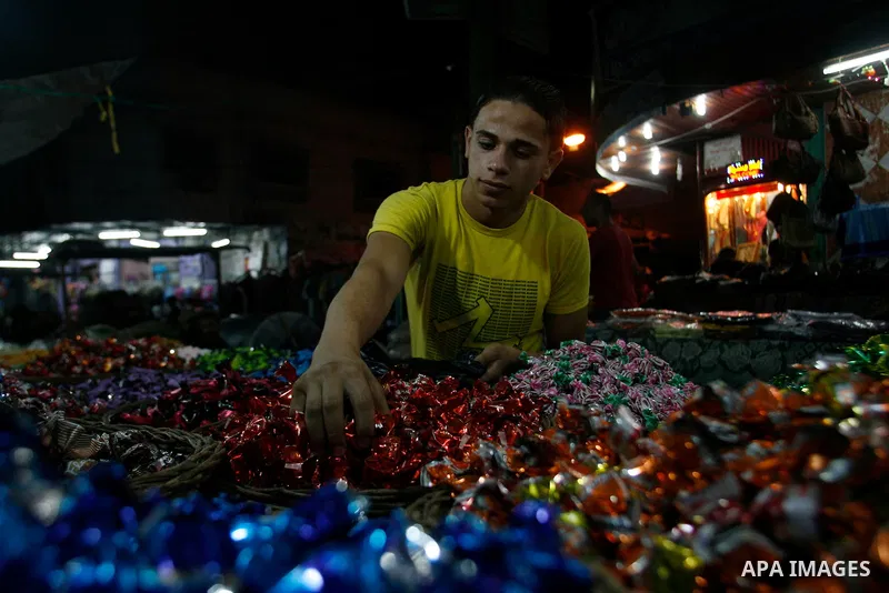 A Palestinian vendor displays his goods at a market in the southern Gaza strip town of Rafah on Aug 16,2012, as Muslims over the world prepare to celebrate Eid al-Fitr, a three day holiday marking the end of the religiou...