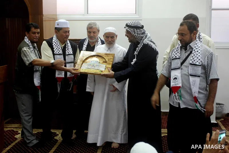 The spokesman of the Palestinian parliament, Ahmed Bahr (C) meets with members of the members "Miles of Smiles 15" aid convoy at a mosque before breaking their fast during the holy month of Ramadan in Gaza city, on Aug 1...