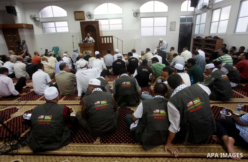 Members of " Miles of Smiles 15 " aid convoy meets with members of Palestinian Parliament at a mosque before breaking their fast during the holy month of Ramadan in Gaza city, on Aug 16, 2012. Photo by Ashraf Amra