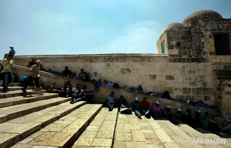 Palestinian Muslim men sit outside the Dome of the Rock at al-Aqsa mosque compound, Islam's third holiest site, on August 17, 2012, in the old city of Jerusalem, on the last Friday of the Muslim holy fasting month of Ram...
