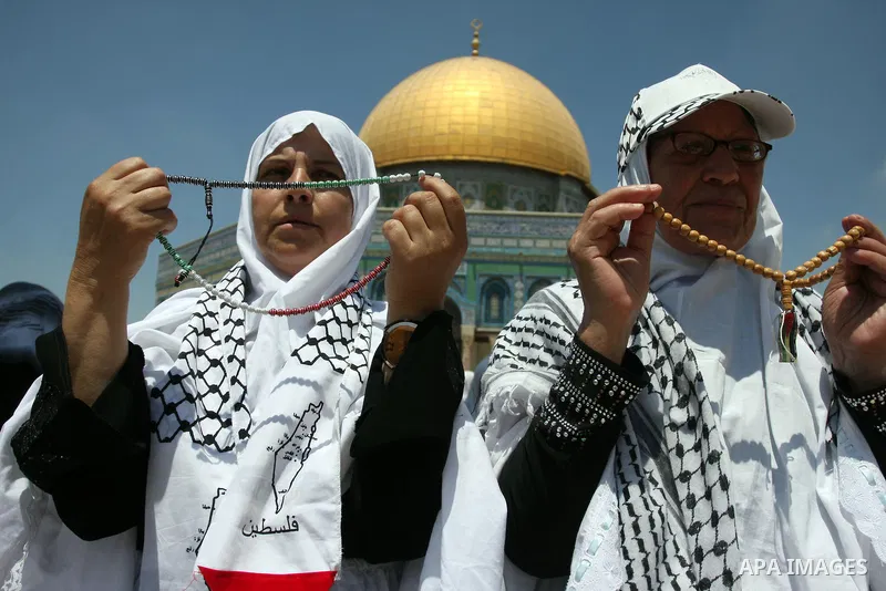 Palestinian women worshippers pray outside the Dome of the Rock at al-Aqsa mosque compound, Islam's third holiest site, on August 17, 2012, in the old city of Jerusalem, on the last Friday of the Muslim holy fasting mont...