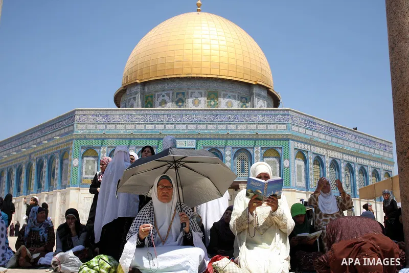Palestinian women worshippers pray outside the Dome of the Rock at al-Aqsa mosque compound, Islam's third holiest site, on August 17, 2012, in the old city of Jerusalem, on the last Friday of the Muslim holy fasting mont...