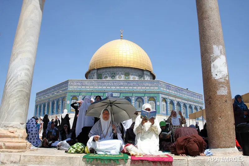 Palestinian women worshippers pray outside the Dome of the Rock at al-Aqsa mosque compound, Islam's third holiest site, on August 17, 2012, in the old city of Jerusalem, on the last Friday of the Muslim holy fasting mont...