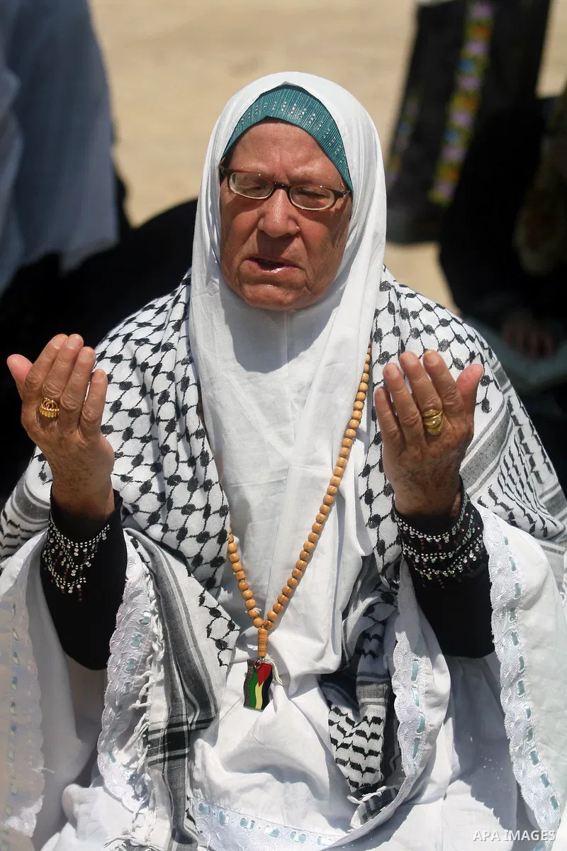 A Palestinian woman prays outside the Dome of the Rock at al-Aqsa mosque compound, Islam's third holiest site, on August 17, 2012, in the old city of Jerusalem, on the last Friday of the Muslim holy fasting month of Rama...
