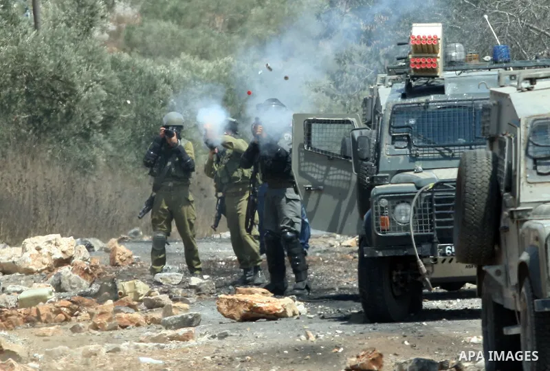 Israeli soldiers fire tear gas at Palestinian protestors during a demonstration against the expropriation of Palestinian land by Israel in the village of Kfar Qaddum, near the West Bank city of Nablus, on August 17, 2012...