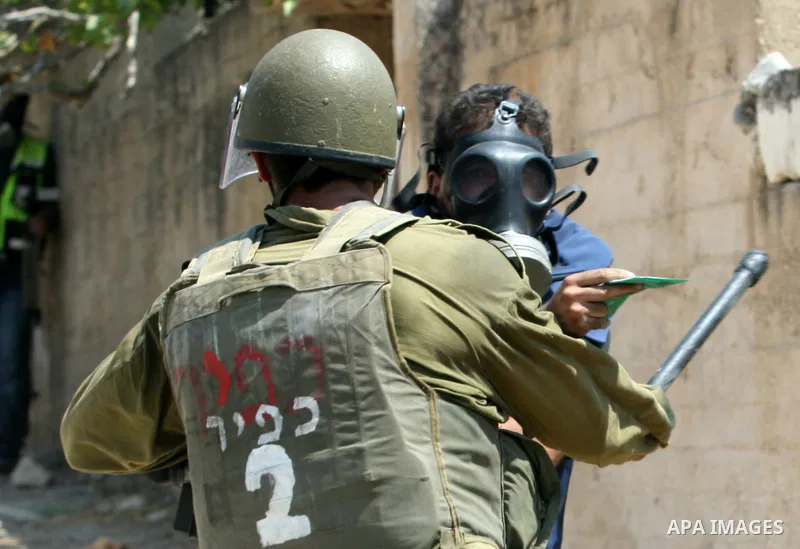 An Israeli soldier hits a Palestinian press photographer during a demonstration against the expropriation of Palestinian land by Israel in the village of Kfar Qaddum, near the West Bank city of Nablus, on August 17, 2012...