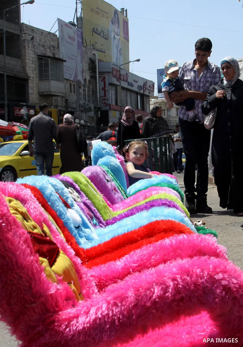Palestinians shop at market during preparations for the Eid Al-Fitr feast in the West Bank city of Nablus on Aug 18, 2012, as Muslims over the world prepare to celebrate Eid al-Fitr, a three day holiday marking the end o...