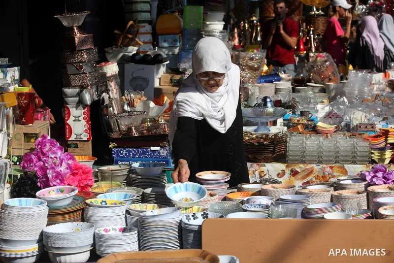 Palestinians woman buys dishes at the main market during preparations for the Eid Al-Fitr feast Gaza city on Aug 18, 2012, as Muslims over the world prepare to celebrate Eid al-Fitr, a three day holiday marking the end o...