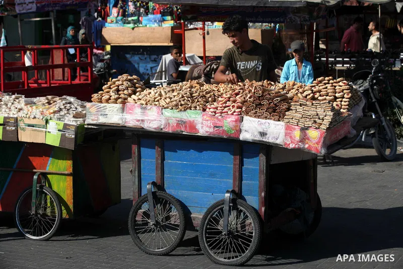 A Palestinian vendor displays the cakes at the main market during preparations for the Eid Al-Fitr feast Gaza city on Aug 18, 2012, as Muslims over the world prepare to celebrate Eid al-Fitr, a three day holiday marking...