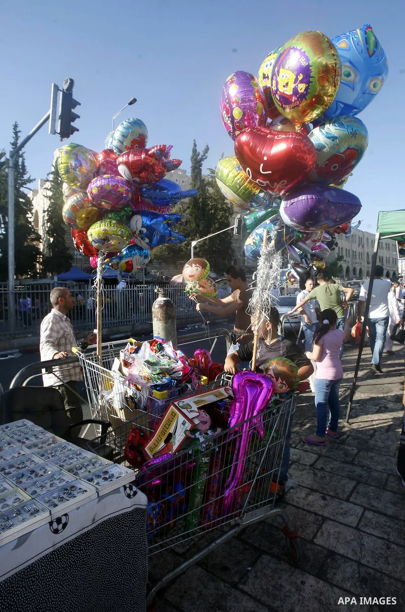 A Palestinian vendor sells toys in the market during preparations for the Eid Al-Fitr feast in Jerusalem's Old City on Aug 16, 2012, as Muslims over the world prepare to celebrate Eid al-Fitr, a three day holiday marking...