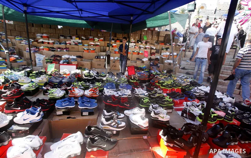 A Palestinian vendor sells shoes in the market during preparations for the Eid Al-Fitr feast in Jerusalem's Old City on Aug 16, 2012, as Muslims over the world prepare to celebrate Eid al-Fitr, a three day holiday markin...