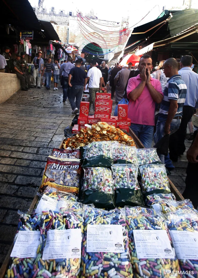 A Palestinian vendor sells candy in the market during preparations for the Eid Al-Fitr feast in Jerusalem's Old City on Aug 16, 2012, as Muslims over the world prepare to celebrate Eid al-Fitr, a three day holiday markin...