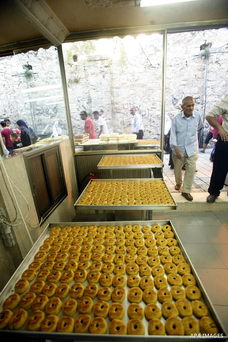 A Palestinian vendor sells cake at his shop in the market during preparations for the Eid Al-Fitr feast in Jerusalem's Old City on Aug 16, 2012, as Muslims over the world prepare to celebrate Eid al-Fitr, a three day hol...