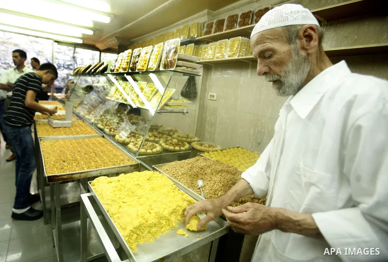 A Palestinian baker makes cake at his shop in the market during preparations for the Eid Al-Fitr feast in Jerusalem's Old City on Aug 16, 2012, as Muslims over the world prepare to celebrate Eid al-Fitr, a three day holi...