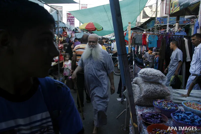 Palestinians shop at the market during preparations for the Eid Al-Fitr feast in Rafah in the southern of Gaza strip on Aug 16, 2012, as Muslims over the world prepare to celebrate Eid al-Fitr, a three day holiday markin...