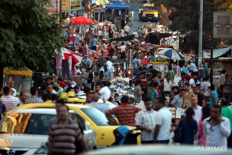 Palestinians shop at the market during preparations for the Eid Al-Fitr feast in the West Bank city of Ramallah, on Aug 16, 2012, as Muslims over the world prepare to celebrate Eid al-Fitr, a three day holiday marking th...