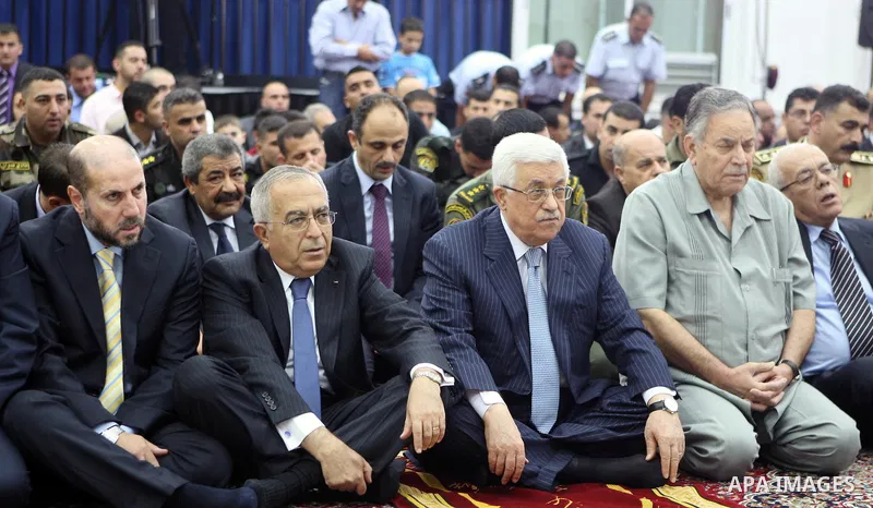 Palestinian President Mahmoud Abbas and his Prime Minister Salam Fayyad attend the early morning Eid Al-Fitr prayer at the Palestinian Authority headquarters in the West Bank city of Ramallah on Aug. 19, 2012 . Muslims o...
