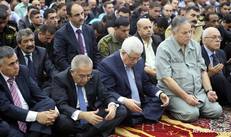 Palestinian President Mahmoud Abbas and his Prime Minister Salam Fayyad attend the early morning Eid Al-Fitr prayer at the Palestinian Authority headquarters in the West Bank city of Ramallah on Aug. 19, 2012 . Muslims o...