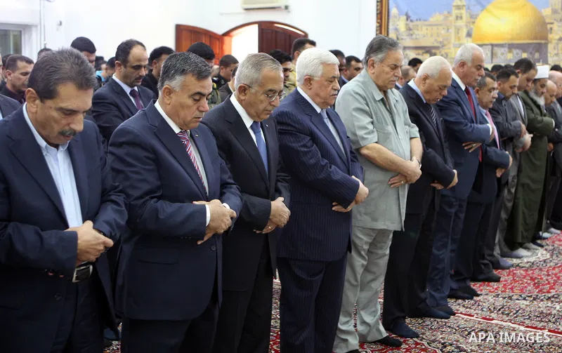 Palestinian President Mahmoud Abbas and his Prime Minister Salam Fayyad attend the early morning Eid Al-Fitr prayer at the Palestinian Authority headquarters in the West Bank city of Ramallah on Aug. 19, 2012 . Muslims o...