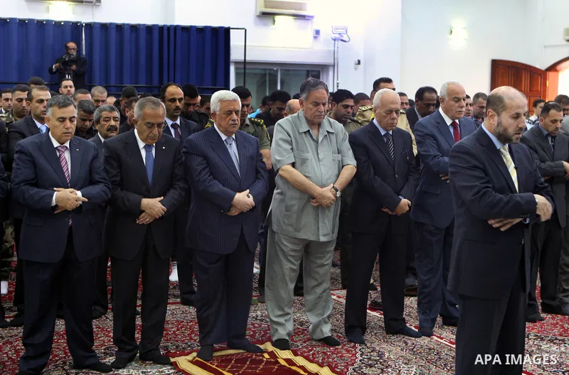 Palestinian President Mahmoud Abbas and his Prime Minister Salam Fayyad attend the early morning Eid Al-Fitr prayer at the Palestinian Authority headquarters in the West Bank city of Ramallah on Aug. 19, 2012 . Muslims o...