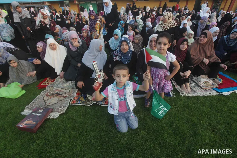 Palestinians attend Eid al-Fitr prayers at the Palestine Stadium in Gaza City August 19, 2012. Eid al-Fitr marks the end of the Muslim holy month of Ramadan. Photo by Ashraf Amra