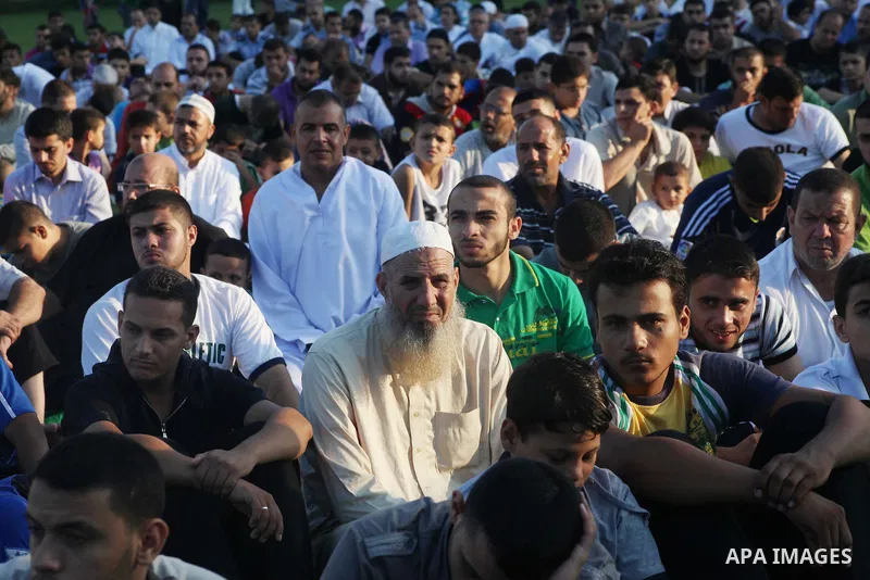 Palestinians attend Eid al-Fitr prayers at the Palestine Stadium in Gaza City August 19, 2012. Eid al-Fitr marks the end of the Muslim holy month of Ramadan. Photo by Ashraf Amra