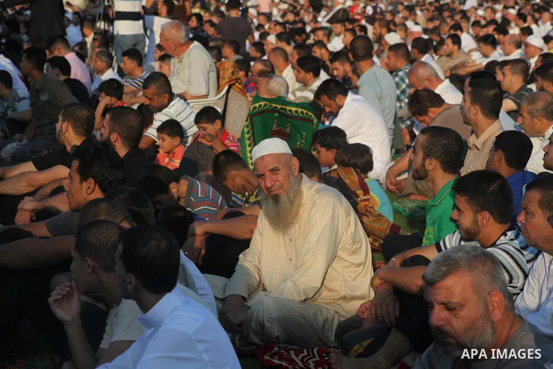Palestinians attend Eid al-Fitr prayers at the Palestine Stadium in Gaza City August 19, 2012. Eid al-Fitr marks the end of the Muslim holy month of Ramadan. Photo by Ashraf Amra