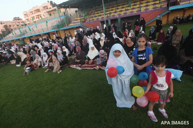 Palestinians attend Eid al-Fitr prayers at the Palestine Stadium in Gaza City August 19, 2012. Eid al-Fitr marks the end of the Muslim holy month of Ramadan. Photo by Ashraf Amra