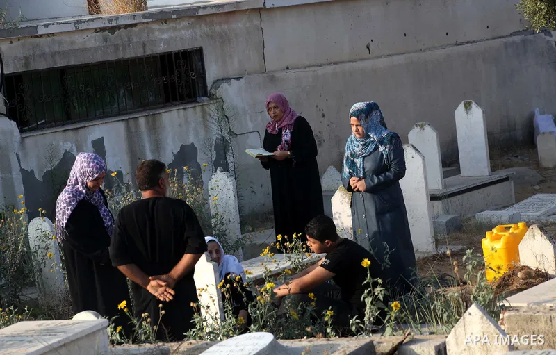 Palestinians visit their relative's graves at a cemetery in Gaza City on the first day of Eid Al-Fitr on Aug. 19, 2012. Eid-Al-Fitr marks the end of the Muslim holy month of Ramadhan. Photo by Ashraf Amra