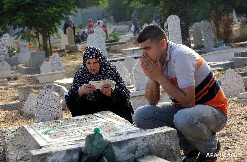 Palestinians visit their relative's graves at a cemetery in Gaza City on the first day of Eid Al-Fitr on Aug. 19, 2012. Eid-Al-Fitr marks the end of the Muslim holy month of Ramadhan. Photo by Ashraf Amra