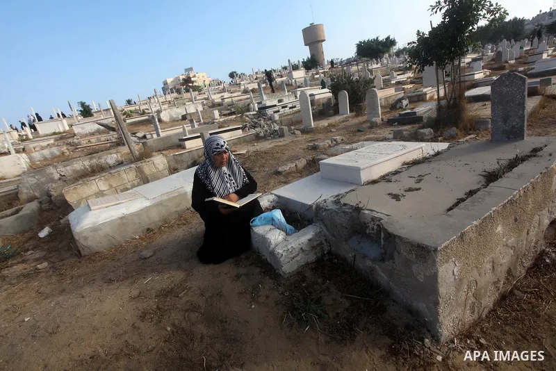Palestinians visit their relative's graves at a cemetery in Gaza City on the first day of Eid Al-Fitr on Aug. 19, 2012. Eid-Al-Fitr marks the end of the Muslim holy month of Ramadhan. Photo by Ashraf Amra