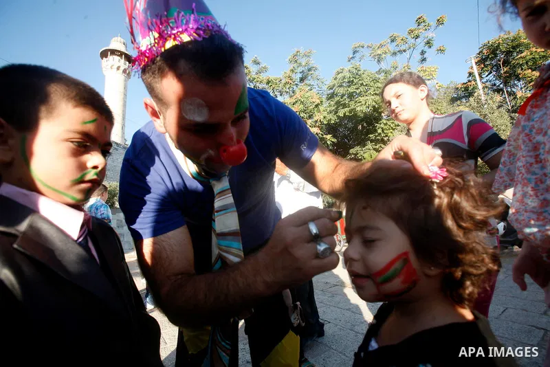 Palestinian painter draw child face in front of the Dome of the Rock mosque during the Eid al-Fitr prayers at al-Aqsa mosque in Jerusalem's Old City, Sunday, Aug. 19, 2012. Muslims are celebrating the festival of Eid al-...