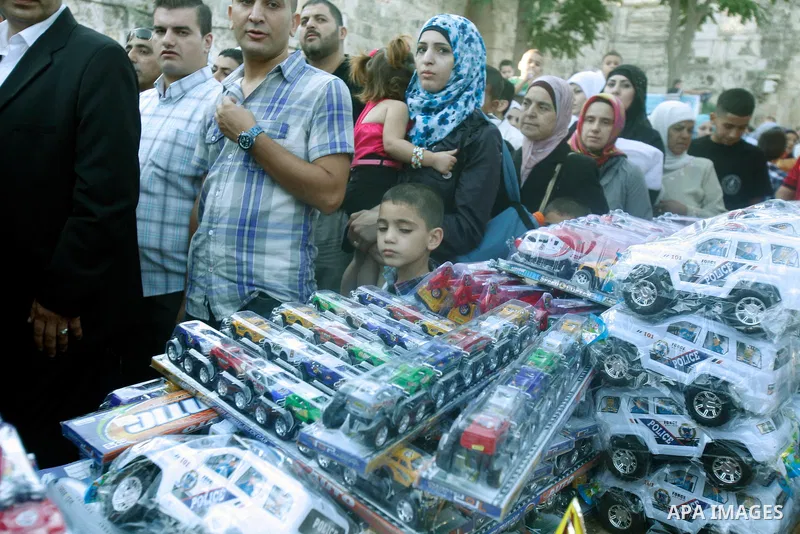 A Palestinian vendor sells toys in front of al-Aqsa mosque compound during the Eid al-Fitr prayers in Jerusalem's Old City, Sunday, Aug. 19, 2012. Muslims are celebrating the festival of Eid al-Fitr which marks the end o...