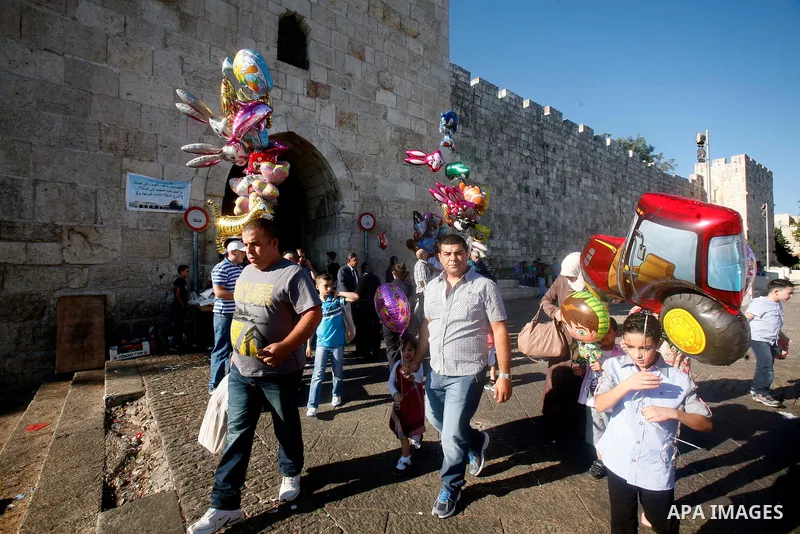 Palestinian hold ballons in front of the Dome of the Rock mosque during the Eid al-Fitr prayers at al-Aqsa mosque in Jerusalem's Old City, Sunday, Aug. 19, 2012. Muslims are celebrating the festival of Eid al-Fitr which...
