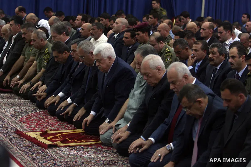 Palestinian President Mahmoud Abbas and his Prime Minister Salam Fayyad attend the early morning Eid Al-Fitr prayer at the Palestinian Authority headquarters in the West Bank city of Ramallah on Aug. 19, 2012 . Muslims o...
