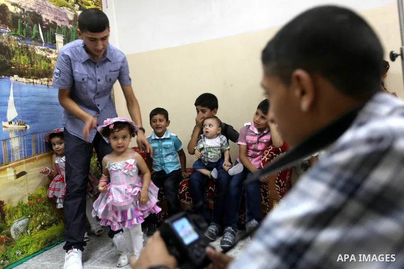 A Palestinian photographer take pictures for children in his studio in Gaza city during the first day of Eid al-Fitr which marks the end of the Muslim fasting month of Ramadan, Sunday, Aug. 19, 2012. Eid, one of the most...