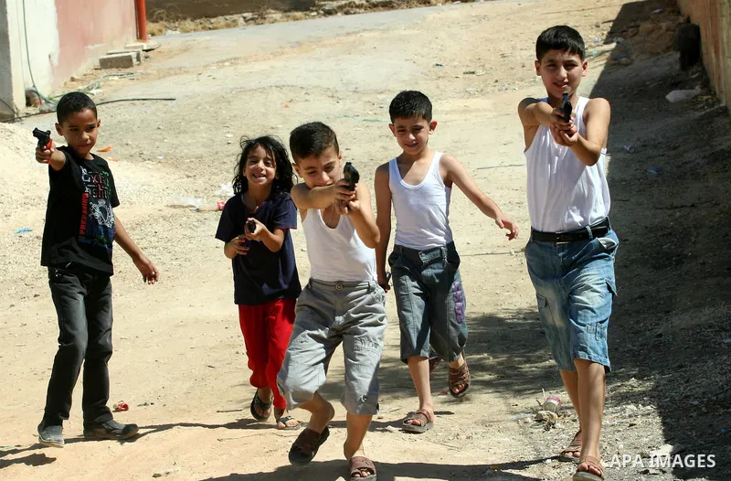 Palestinian children play with a toy gun on the Second day of Eid al-Fitr in the West Bank city of Nablus, Aug. 20, 2012. which marks the end of the Muslim fasting month of Ramadan. Eid, one of the most important holiday...