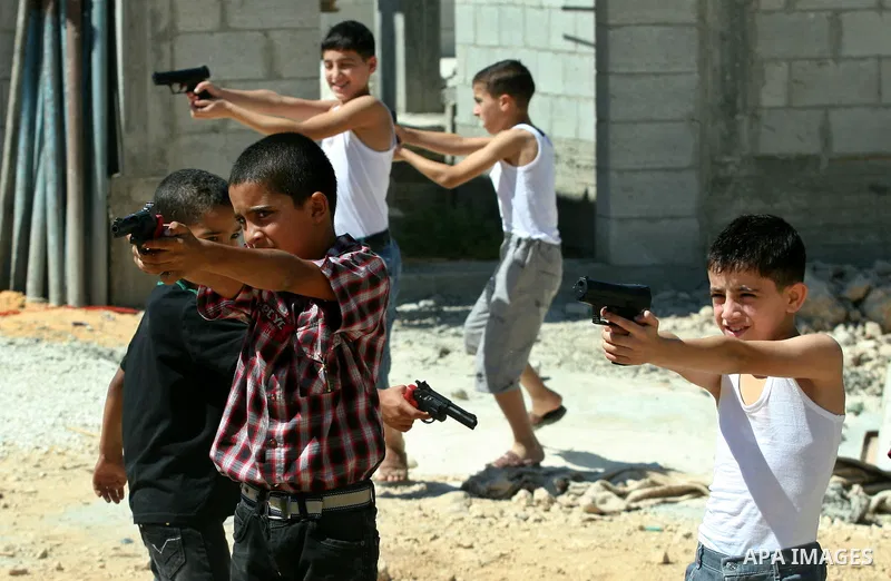 Palestinian children play with a toy gun on the Second day of Eid al-Fitr in the West Bank city of Nablus, Aug. 20, 2012. which marks the end of the Muslim fasting month of Ramadan. Eid, one of the most important holiday...