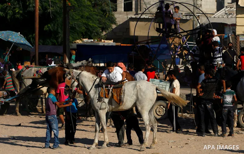 Palestinian children play during the Second day of Eid al-Fitr in Rafah in the southern of Gaza strip, Aug. 20, 2012. which marks the end of the Muslim fasting month of Ramadan. Eid, one of the most important holidays in...