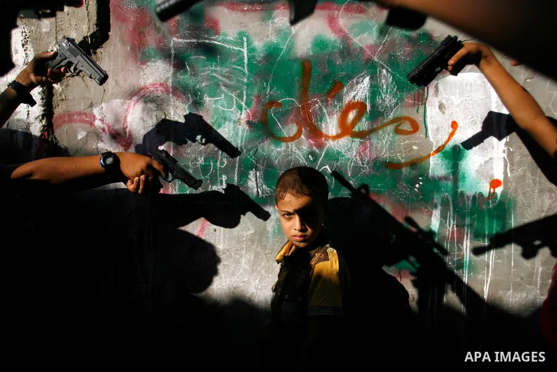 Palestinian children play with a gun toy on the Second day of Eid al-Fitr in Rafah in the southern of Gaza strip, Aug. 20, 2012. which marks the end of the Muslim fasting month of Ramadan. Eid, one of the most important...