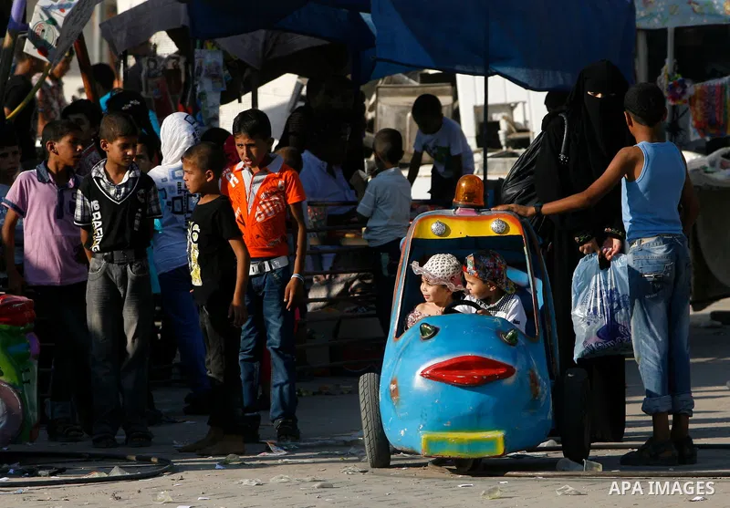 Palestinian children play during the Second day of Eid al-Fitr in Rafah in the southern of Gaza strip, Aug. 20, 2012. which marks the end of the Muslim fasting month of Ramadan. Eid, one of the most important holidays in...