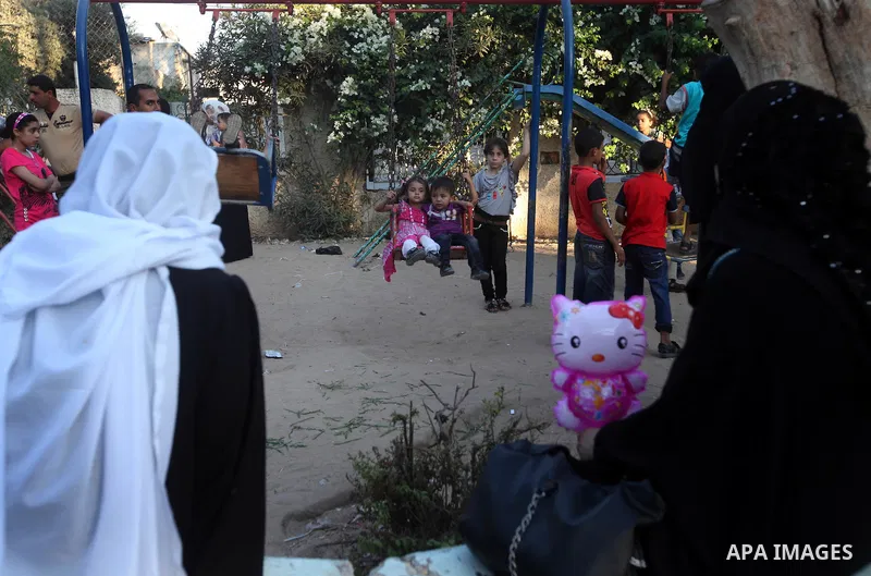 Palestinians stroll at a park during the Second day of Eid al-Fitr in Gaza city, Aug. 20, 2012. which marks the end of the Muslim fasting month of Ramadan. Eid, one of the most important holidays in the Muslim world, is...