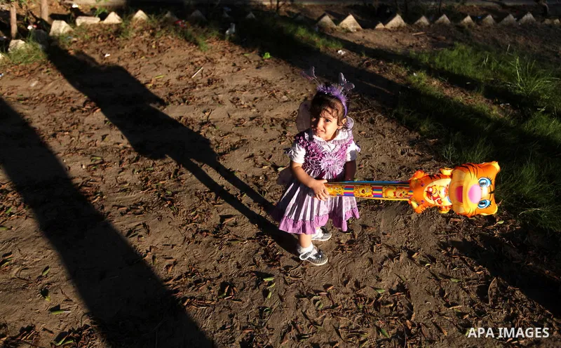 A Palestinian girl carries a ballon at a park during the Second day of Eid al-Fitr in Gaza city, Aug. 20, 2012. which marks the end of the Muslim fasting month of Ramadan. Eid, one of the most important holidays in the M...