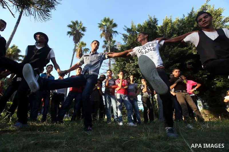Palestinian youths dance at a park during the Second day of Eid al-Fitr in Gaza city, Aug. 20, 2012. which marks the end of the Muslim fasting month of Ramadan. Eid, one of the most important holidays in the Muslim world...