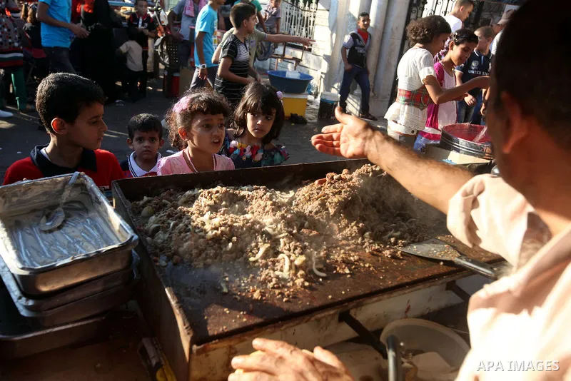A Palestinian man sells meat sandwiches at a park during the Second day of Eid al-Fitr in Gaza city, Aug. 20, 2012. which marks the end of the Muslim fasting month of Ramadan. Eid, one of the most important holidays in t...