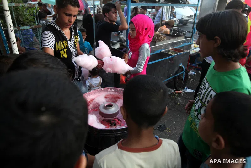 Palestinian children buy cotton candy in front of a park during the Second day of Eid al-Fitr in Gaza city, Aug. 20, 2012. which marks the end of the Muslim fasting month of Ramadan. Eid, one of the most important holida...