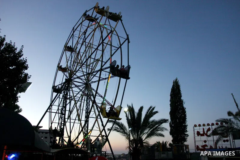 Palestinians enjoy the second day of Eid al-Fitr in an amusement park, in the West Bank city of Ramallah, Monday, Aug. 20, 2012. Eid, one of the most important holidays in the Muslim world, is marked with prayers, family...