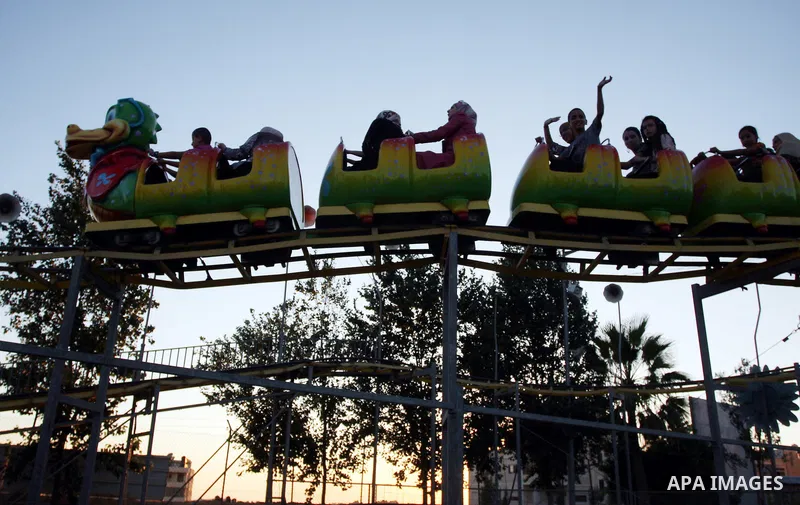 Palestinians enjoy the second day of Eid al-Fitr in an amusement park, in the West Bank city of Ramallah, Monday, Aug. 20, 2012. Eid, one of the most important holidays in the Muslim world, is marked with prayers, family...