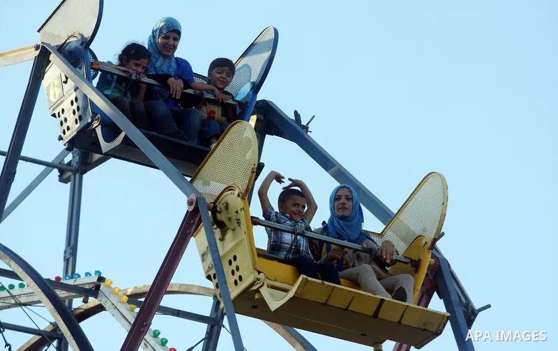 Palestinians enjoy the second day of Eid al-Fitr in an amusement park, in the West Bank city of Ramallah, Monday, Aug. 20, 2012. Eid, one of the most important holidays in the Muslim world, is marked with prayers, family...